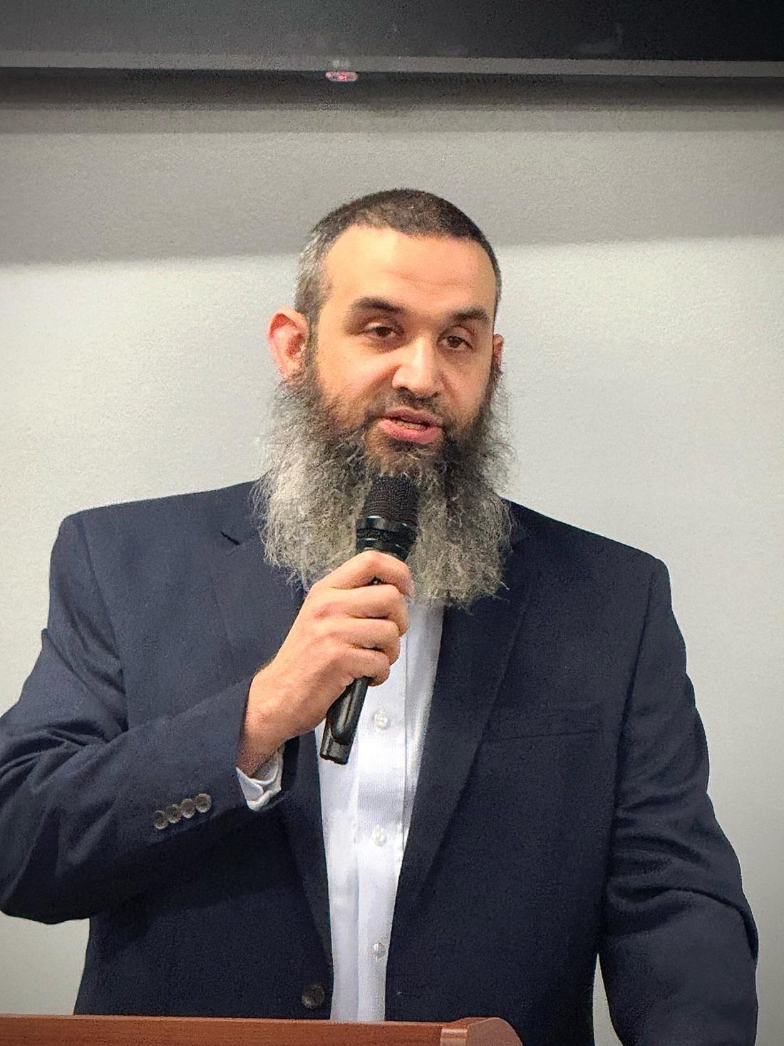 Michael Abraham speaking with a microphone